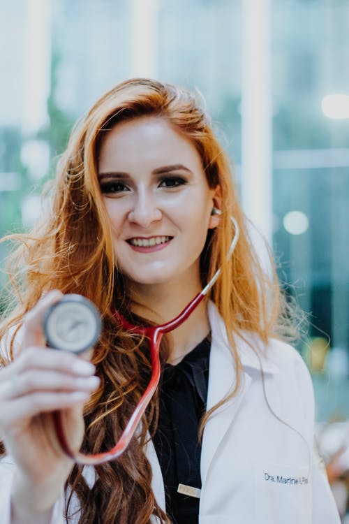 Female Brisbane home doctor holding a stethoscope