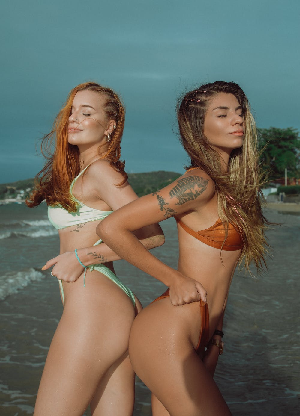 Two women flaunting their thong swimsuit bottoms